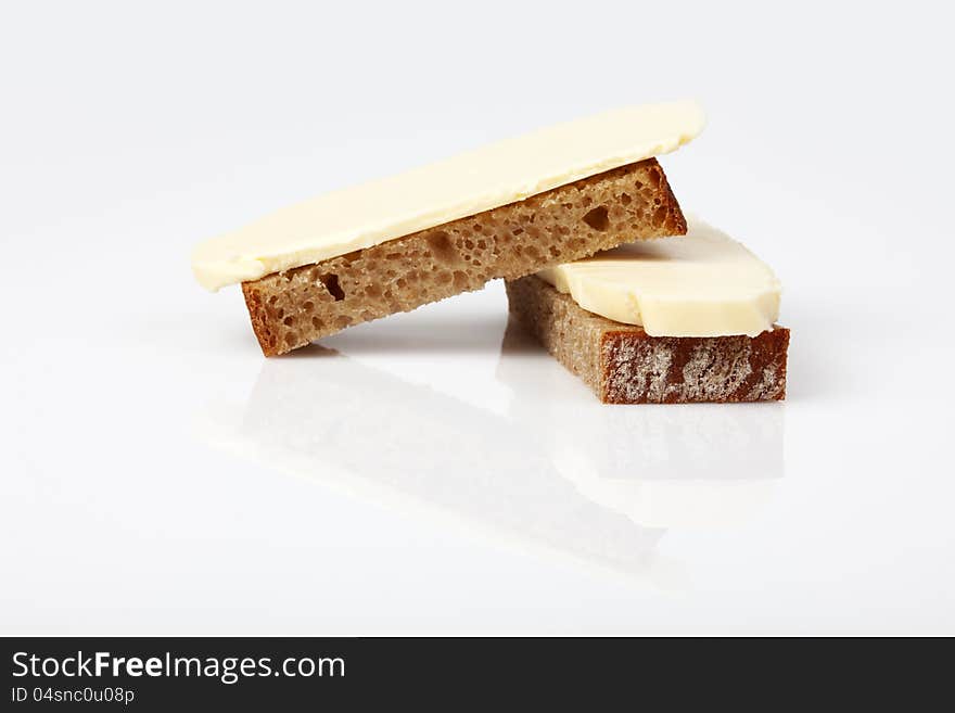 Sliced ​​fresh rye bread on top of the butter, studio shot on white background. Sliced ​​fresh rye bread on top of the butter, studio shot on white background