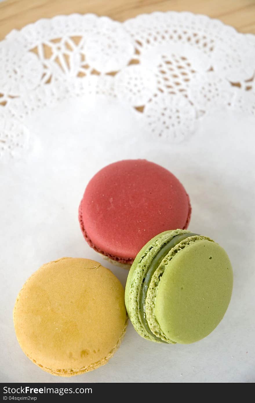 Three colorful macarons on white background