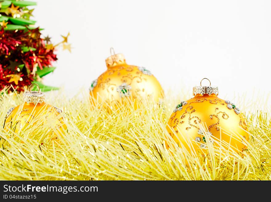 Three Christmas balls on yellow tinsel