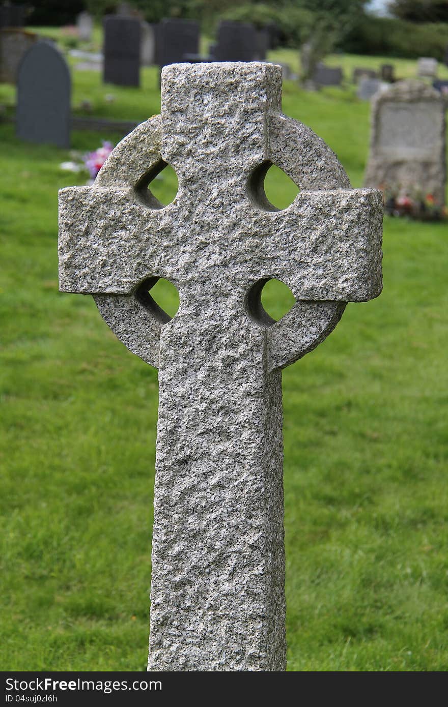 A Celtic Stone Cross Standing in a Graveyard. A Celtic Stone Cross Standing in a Graveyard.