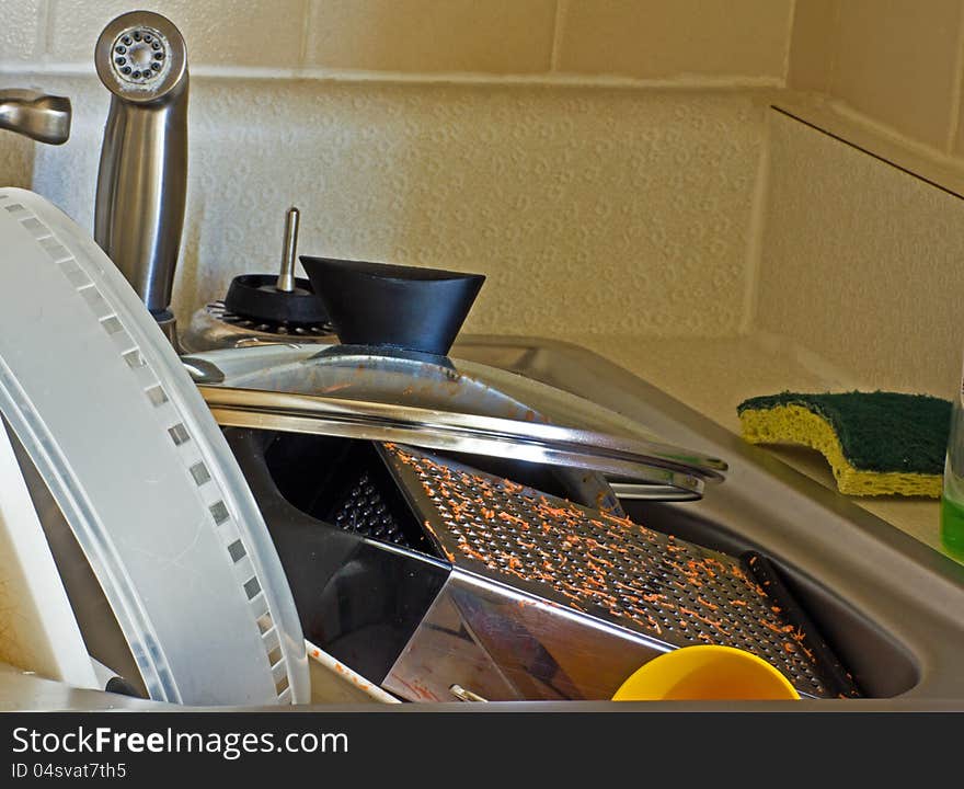 Sink full of dirty dishes and cookware.