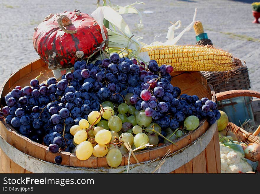 Bunches of grapes - autumn vegetables seasonal exposed outdoor on wooden barrel. Bunches of grapes - autumn vegetables seasonal exposed outdoor on wooden barrel