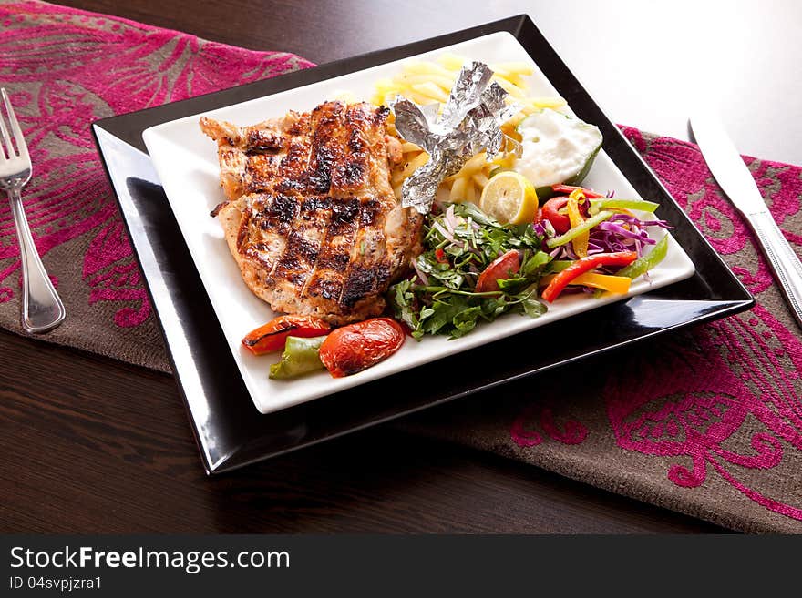 Grilled chicken with chips and vegetables