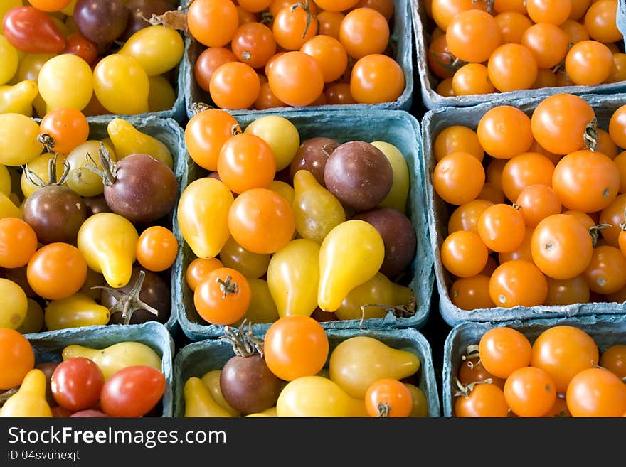 Fresh baby tomatoes of different colors for sale in a farmers market. Fresh baby tomatoes of different colors for sale in a farmers market