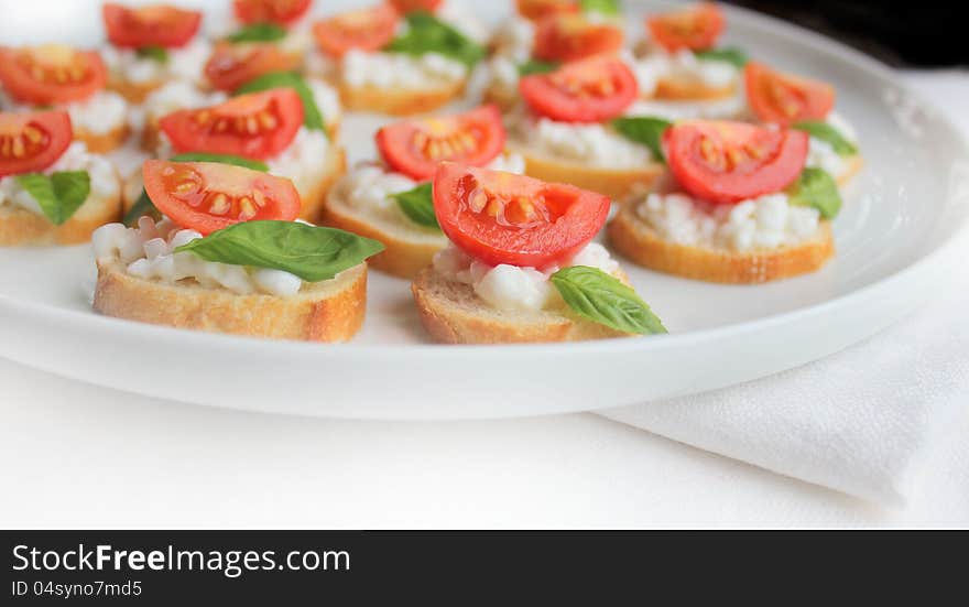 Italian bruschetta with cherry tomato,basil and cheese on white plate