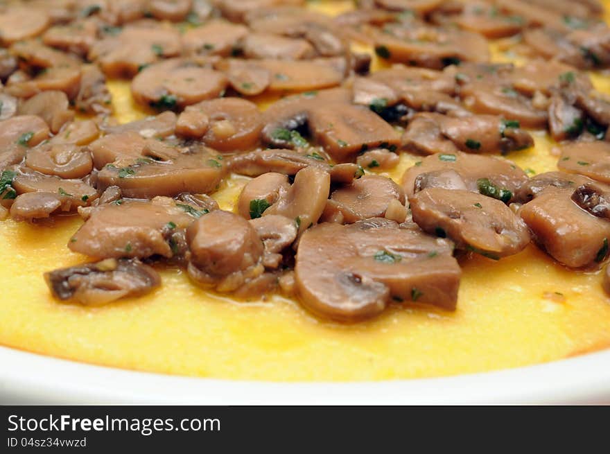 Closeup of polenta served with mushrooms and parsley. Closeup of polenta served with mushrooms and parsley