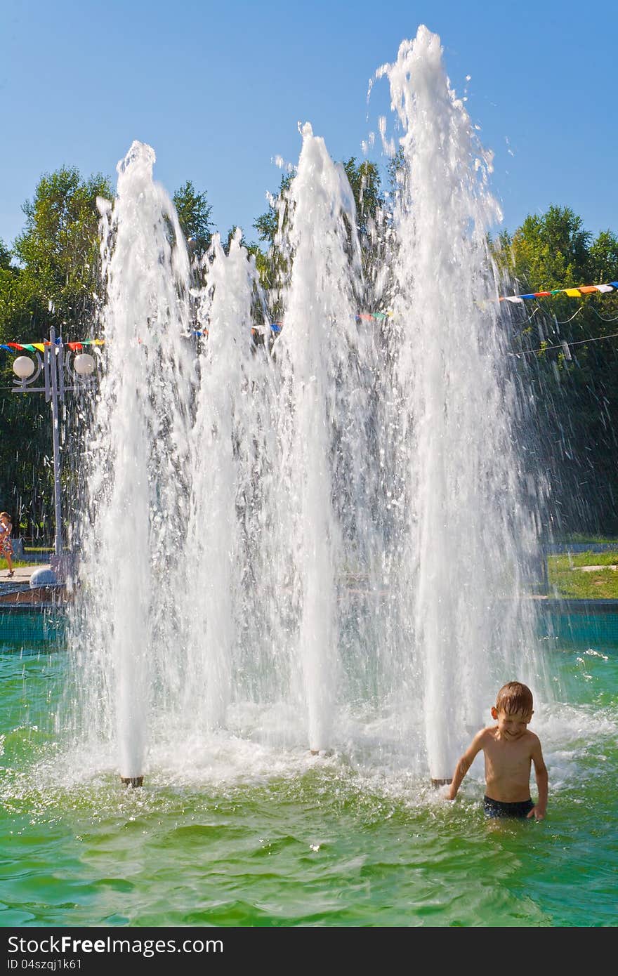 The boy bathes in a fountain