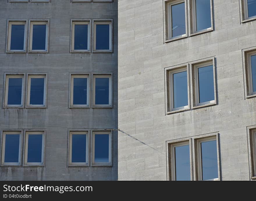 Two similar facades of a modern office building are seen in shadow and sunlight. Two similar facades of a modern office building are seen in shadow and sunlight