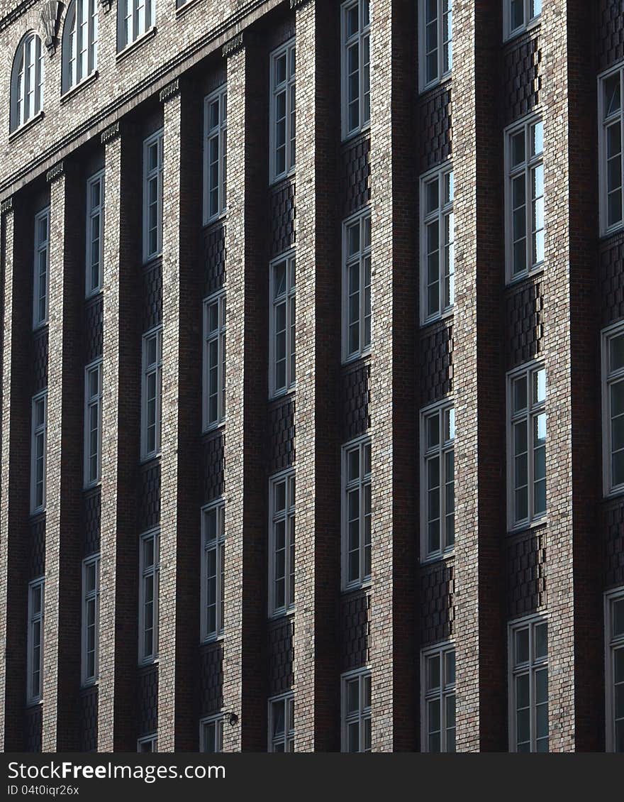 The morning sun creates a gilded effect on the columns of a multistory brick building. The morning sun creates a gilded effect on the columns of a multistory brick building