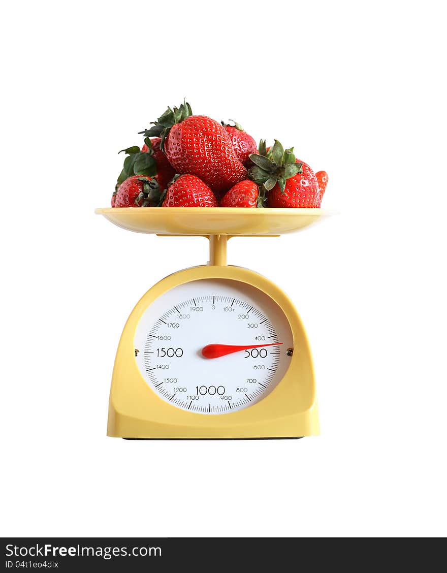 Heap of strawberry fruits lying on nice yellow kitchen scale. Isolated on white with clipping path. Heap of strawberry fruits lying on nice yellow kitchen scale. Isolated on white with clipping path