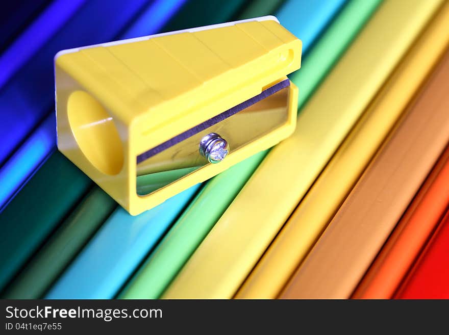 Closeup of yellow sharpener on color pencils surfase. Closeup of yellow sharpener on color pencils surfase