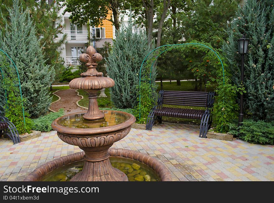 Fine bronze Fountain in park among trees