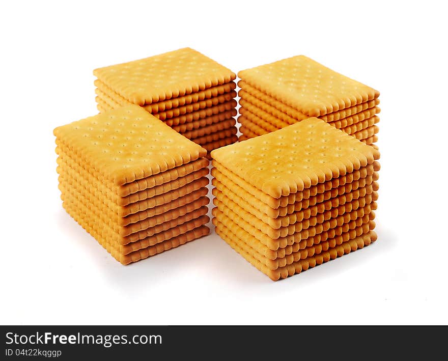 Four stacks of tea biscuits arranged in a cross isolated on a white background. Four stacks of tea biscuits arranged in a cross isolated on a white background