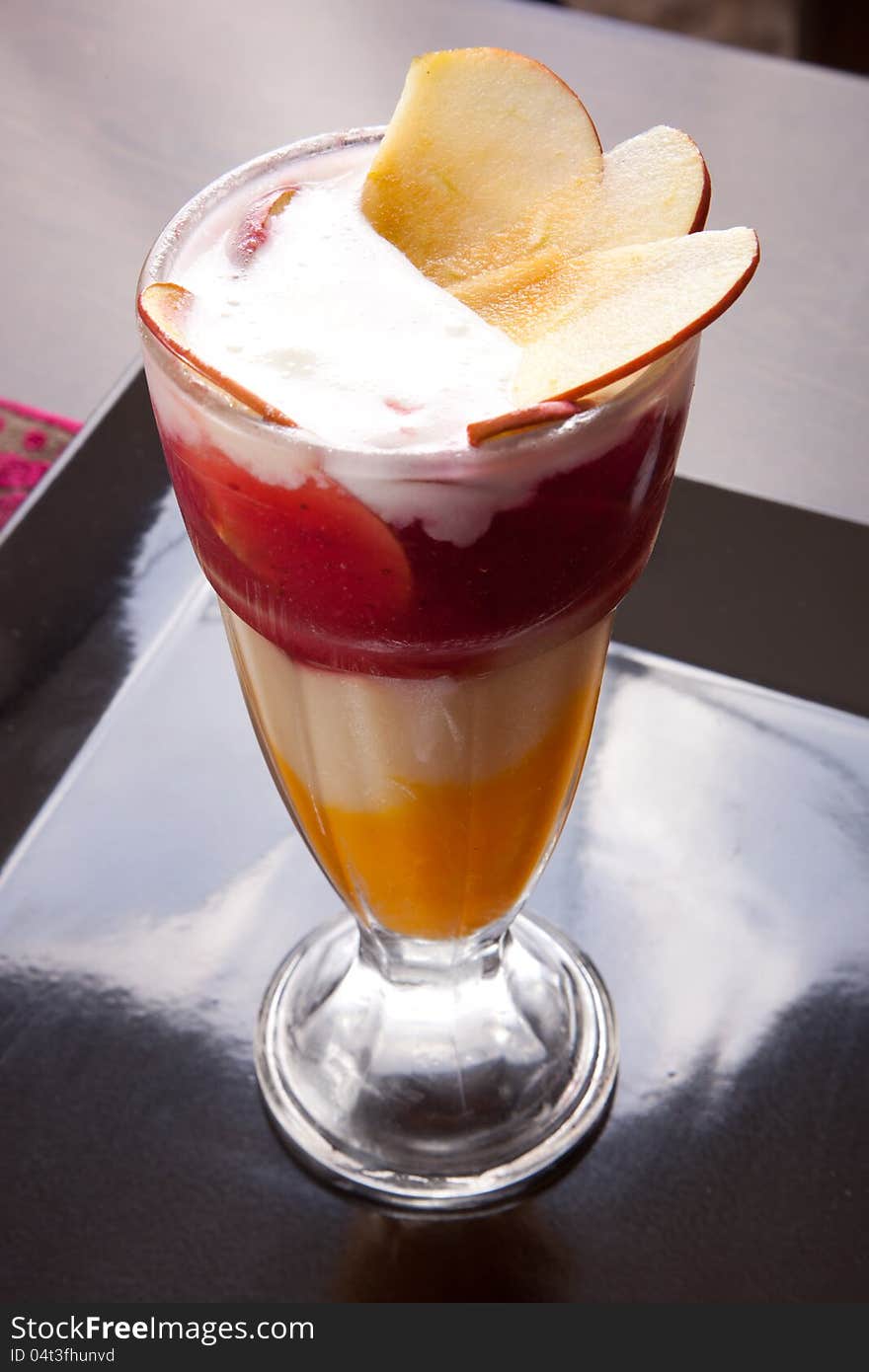 Fruit cocktail glass with Pieces of apple on black dish