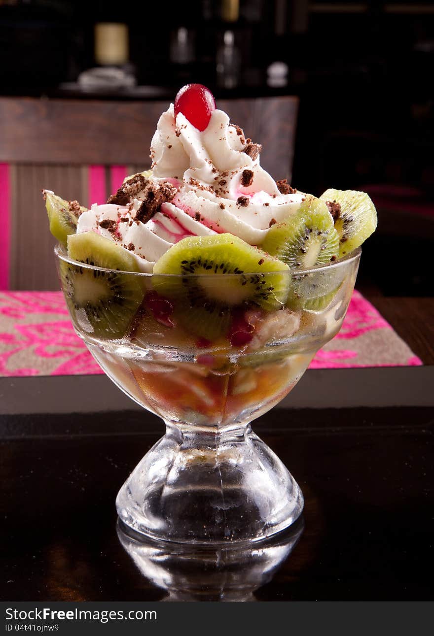 Fruit salad topped with cream and grapes and kiwi. Fruit salad topped with cream and grapes and kiwi