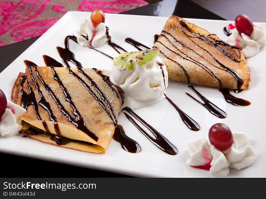 Pancakes with ice cream & chocolate souse on white plate. Pancakes with ice cream & chocolate souse on white plate