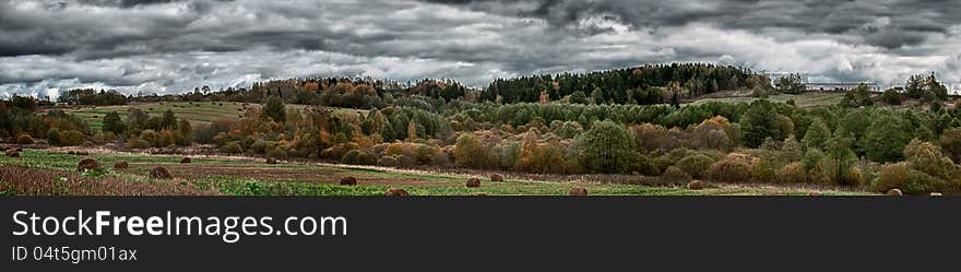 Panorama of rural landscape with yellow trees, straw bales and dramatic sky in autumn – HDR image. Panorama of rural landscape with yellow trees, straw bales and dramatic sky in autumn – HDR image