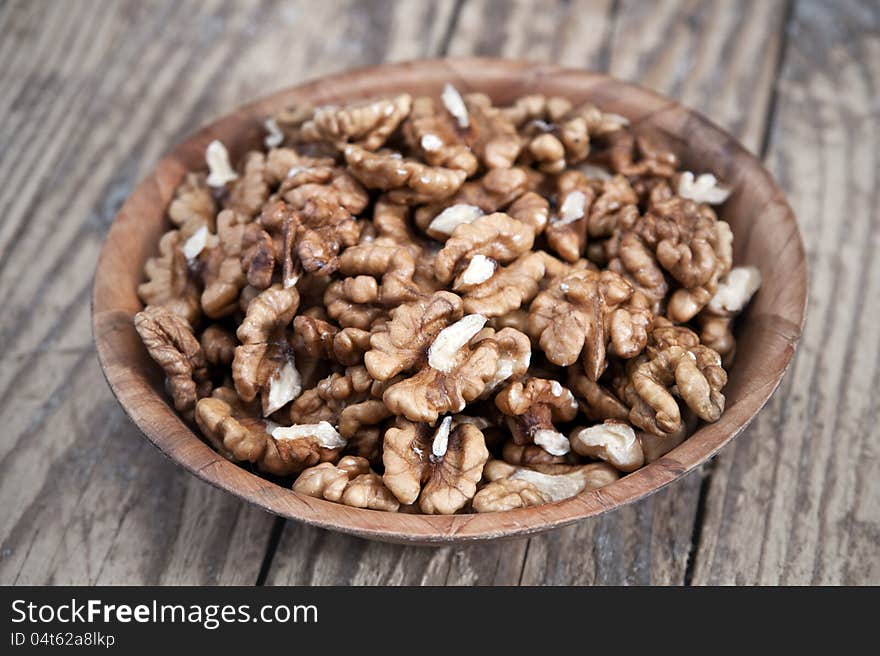 Walnut in wooden bowl on wooden table