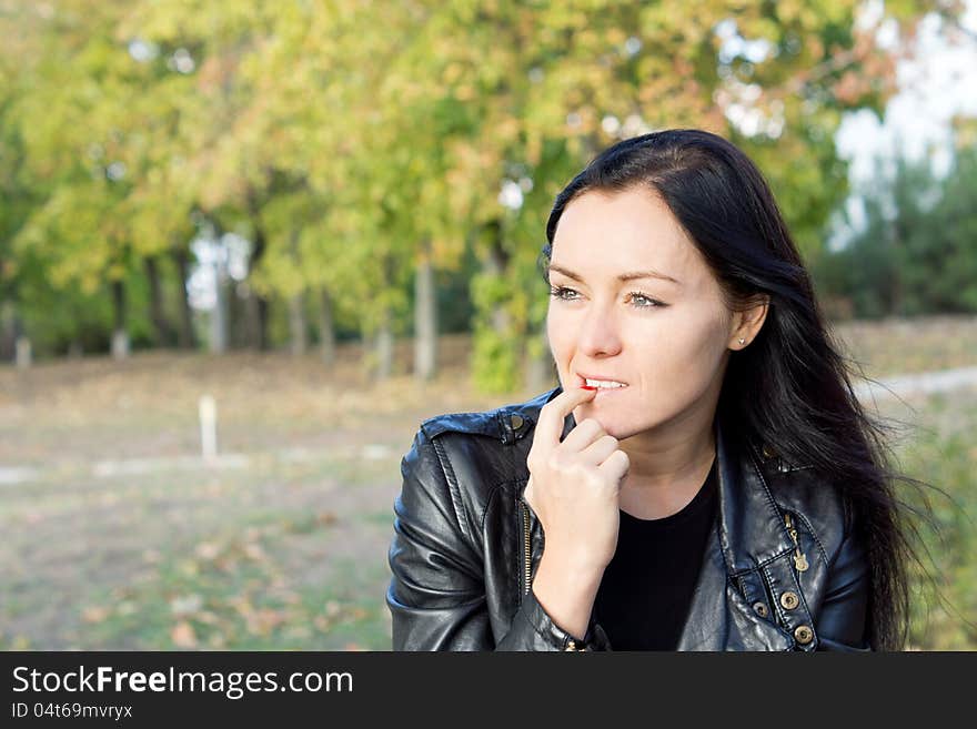 Pensive woman sitting outdoors in the countryside thinking and staring into the distance with copyspace. Pensive woman sitting outdoors in the countryside thinking and staring into the distance with copyspace