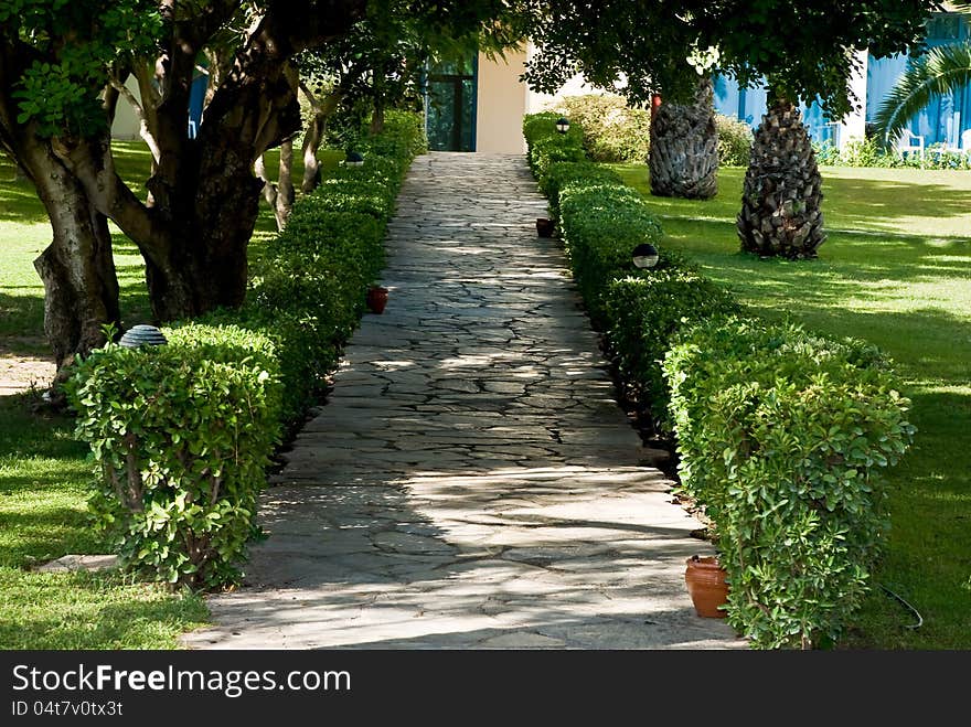 Corridor in a park with green meadows and trees around