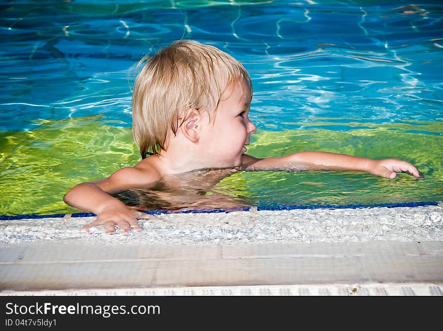 Young smiling boy in the swimming pool