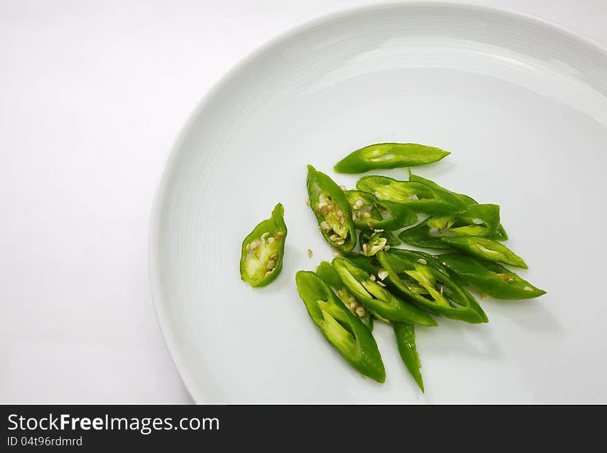 Green chili in white plate on white background