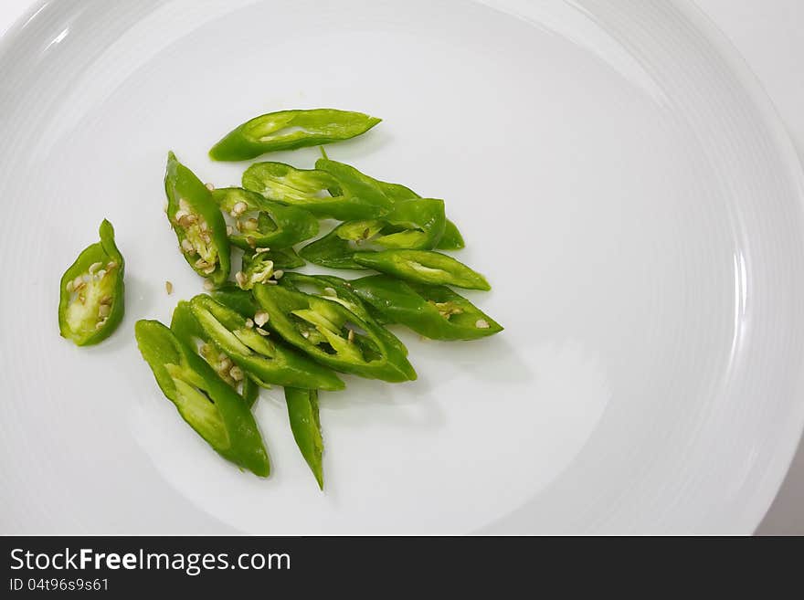 Green chili in white plate on white background