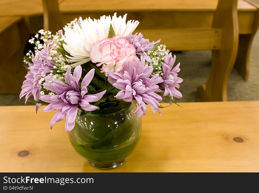 A jar of mixed flowers on table. A jar of mixed flowers on table