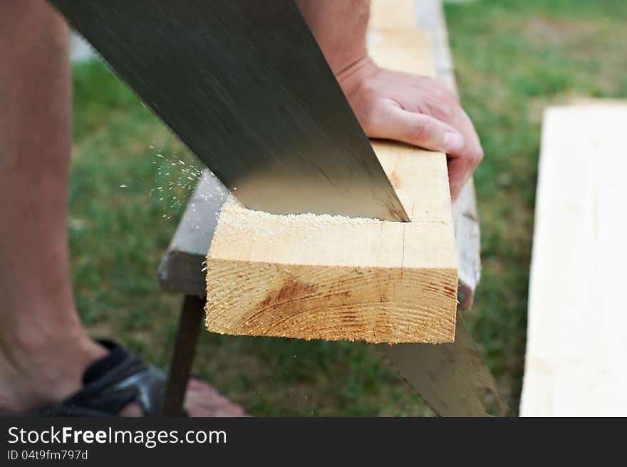 Man sawing a wooden board