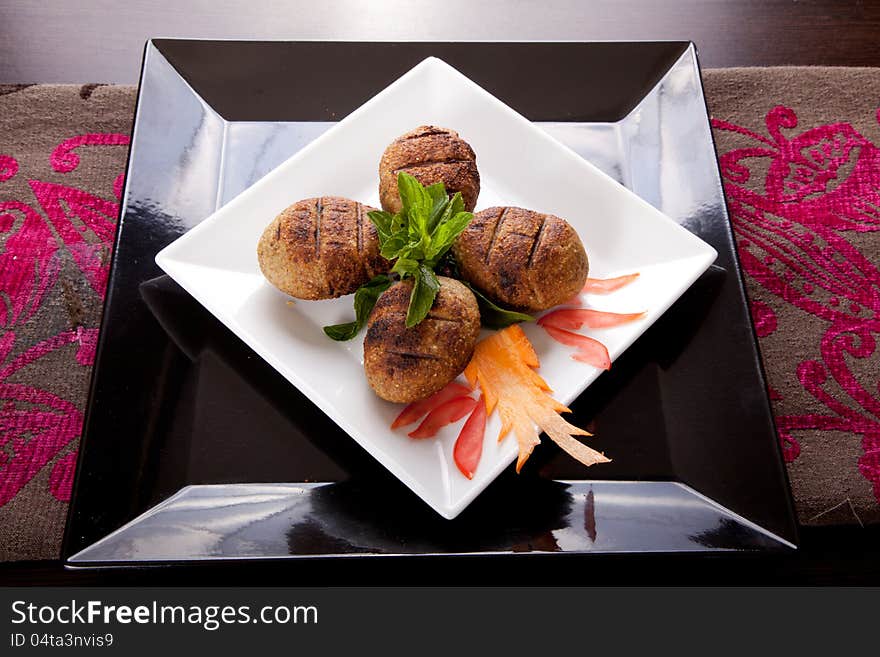 Oriental grilled meat balls on white dish and black underline ( Kebab ). Oriental grilled meat balls on white dish and black underline ( Kebab )