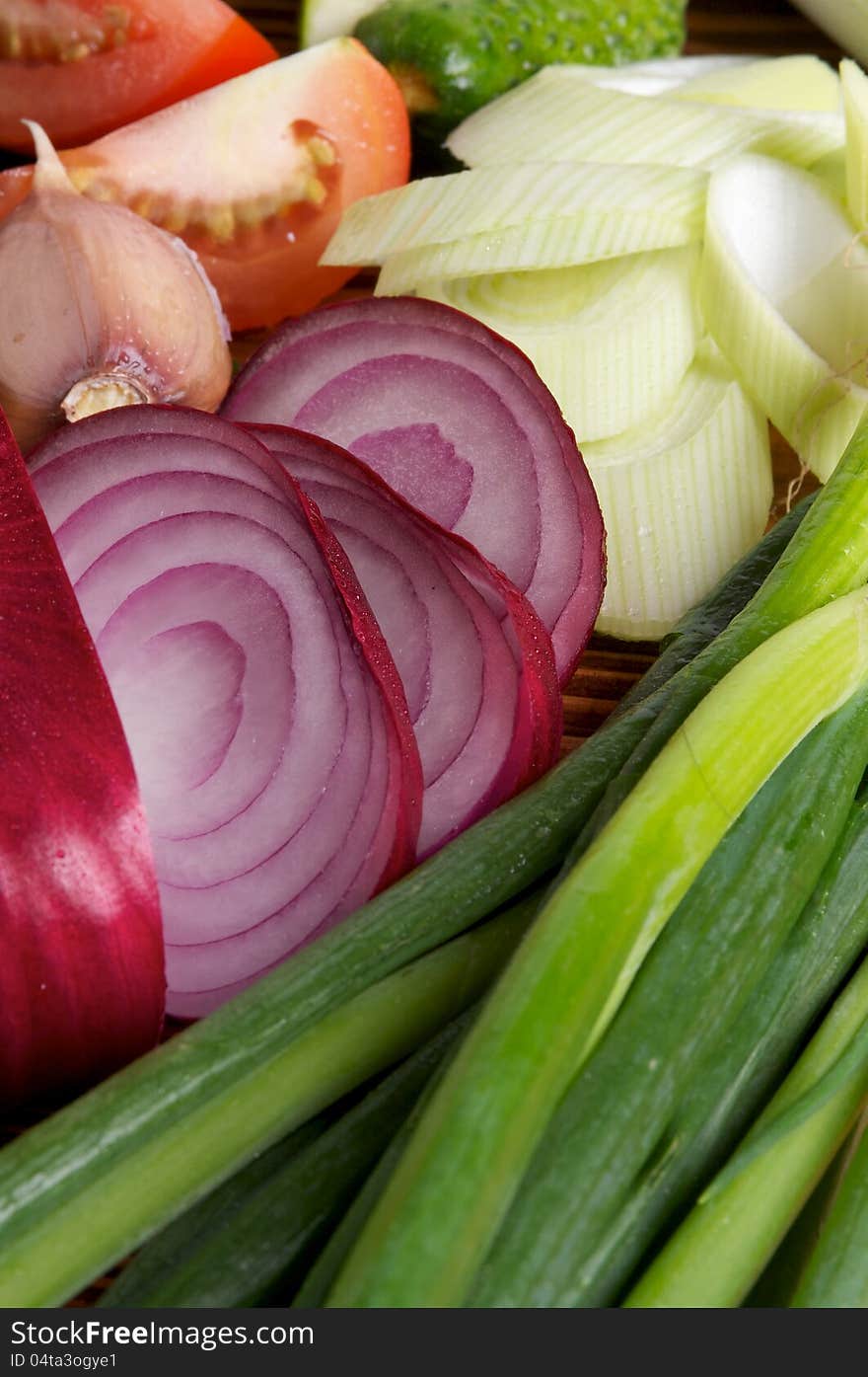 Red Onion and Various Vegetables with Leek, Garlic, Luttuce, Cucucmber and Tomatoes as background. Red Onion and Various Vegetables with Leek, Garlic, Luttuce, Cucucmber and Tomatoes as background