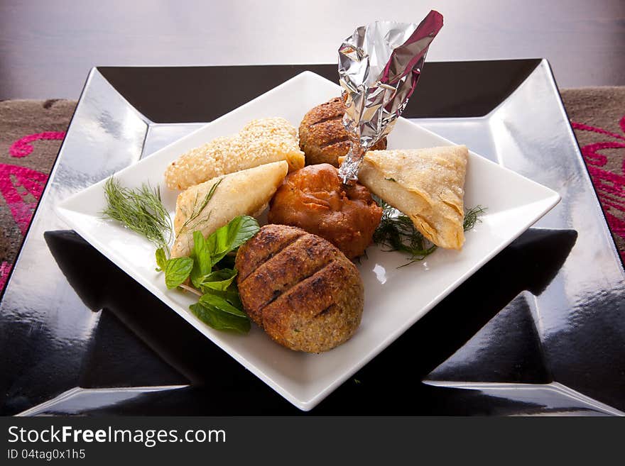 Selection of Indian appetizers including curries, rice, samosas and naan bread.