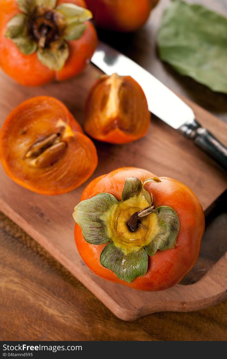 Ripe persimmon on a cutting wooden board