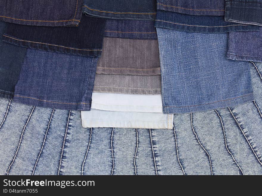 Background piece leg jeans are stacked neatly on a large piece of denim. Background piece leg jeans are stacked neatly on a large piece of denim.