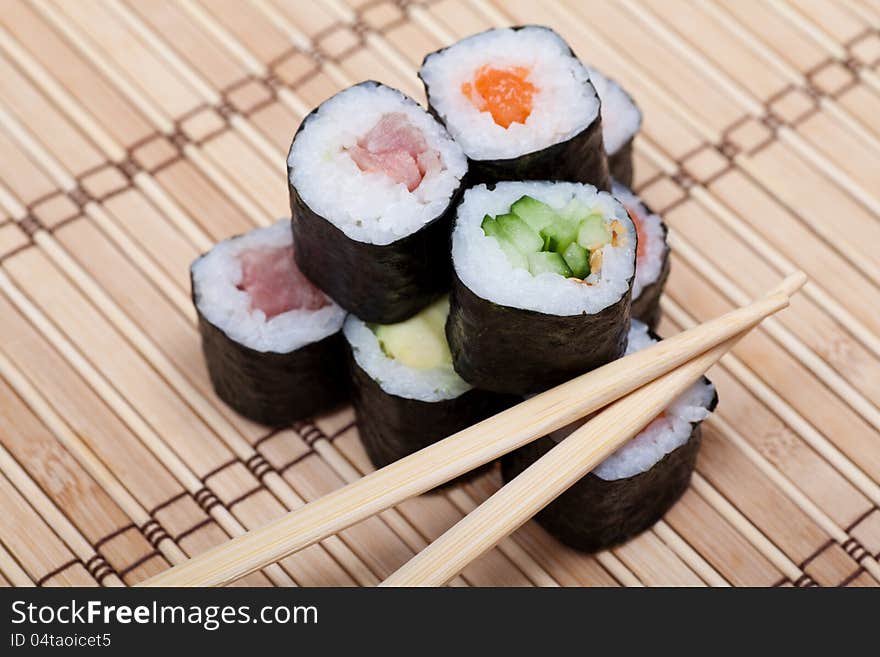 Chopsticks and sushi on bamboo mat