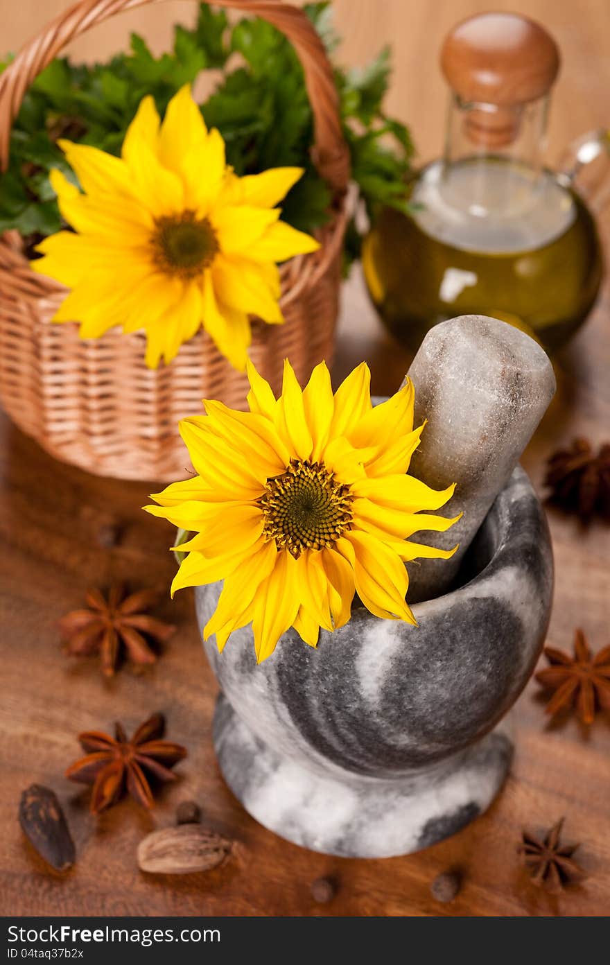 Spices, olive oil and sunflower flower in a mortar