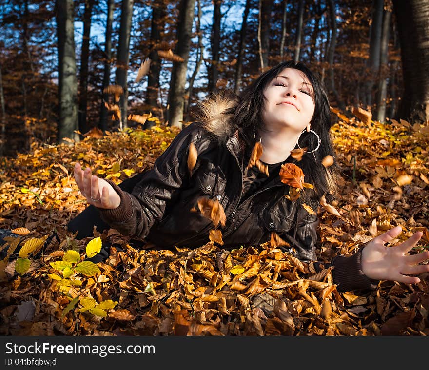 Young woman lying in fallen leaves