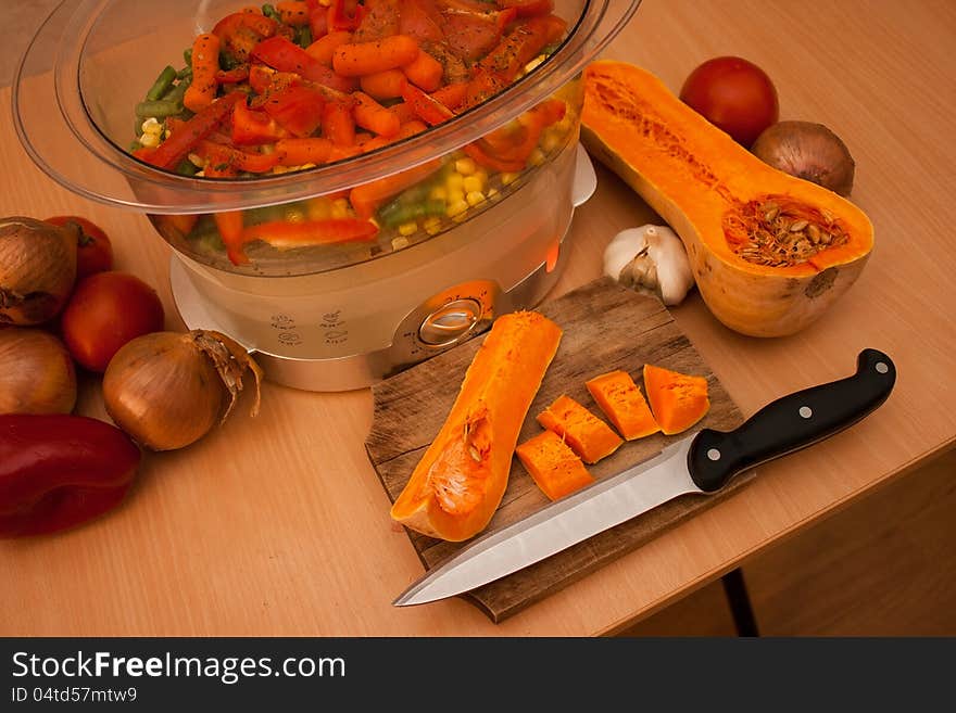 Cutting up vegetables and cooking in a steam pot. Cutting up vegetables and cooking in a steam pot