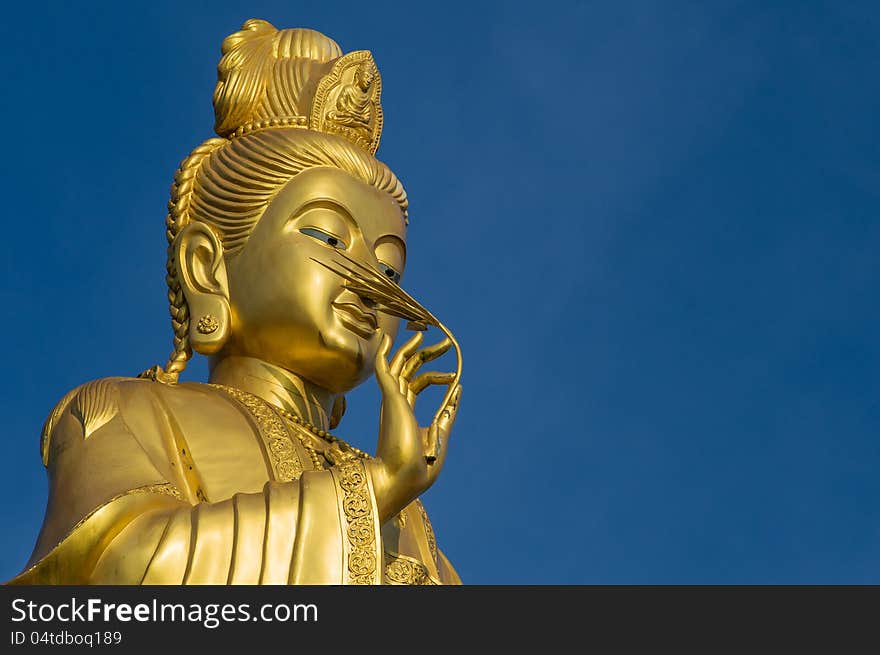 Clos up shot of Golden Guanyin standing with bluesky in Buddhist temple. Clos up shot of Golden Guanyin standing with bluesky in Buddhist temple