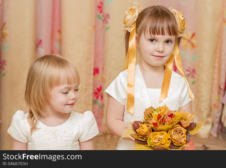 Two little girl with bouquet of autumn leaves