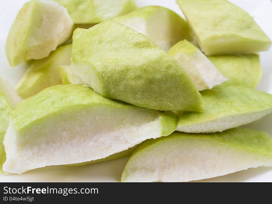 Fresh cut piece tropical green guava on white plate. Fresh cut piece tropical green guava on white plate.