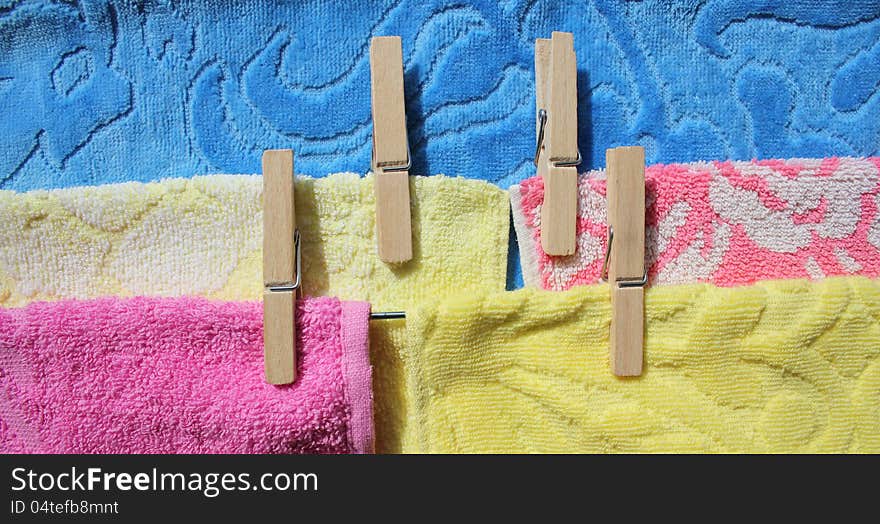 Laundry ( towels of pink, yellow, blue color) on a clothes-line