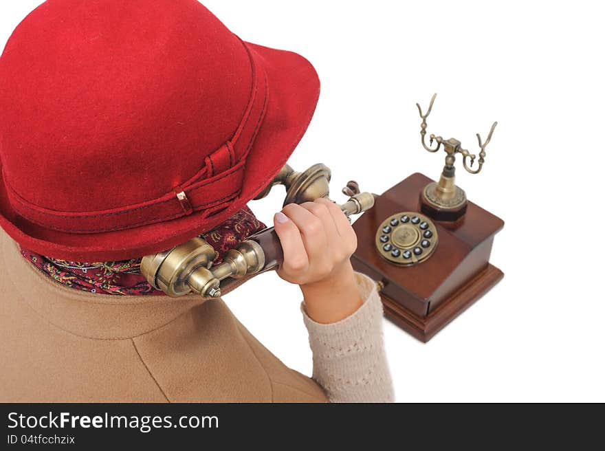 Old-fashioned woman in red hat is talking old-fashioned phone on white isolated background. Old-fashioned woman in red hat is talking old-fashioned phone on white isolated background