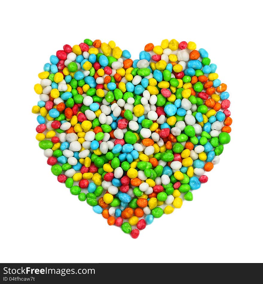 Heart symbol laid out from colorful candies on white with shadows. Heart symbol laid out from colorful candies on white with shadows