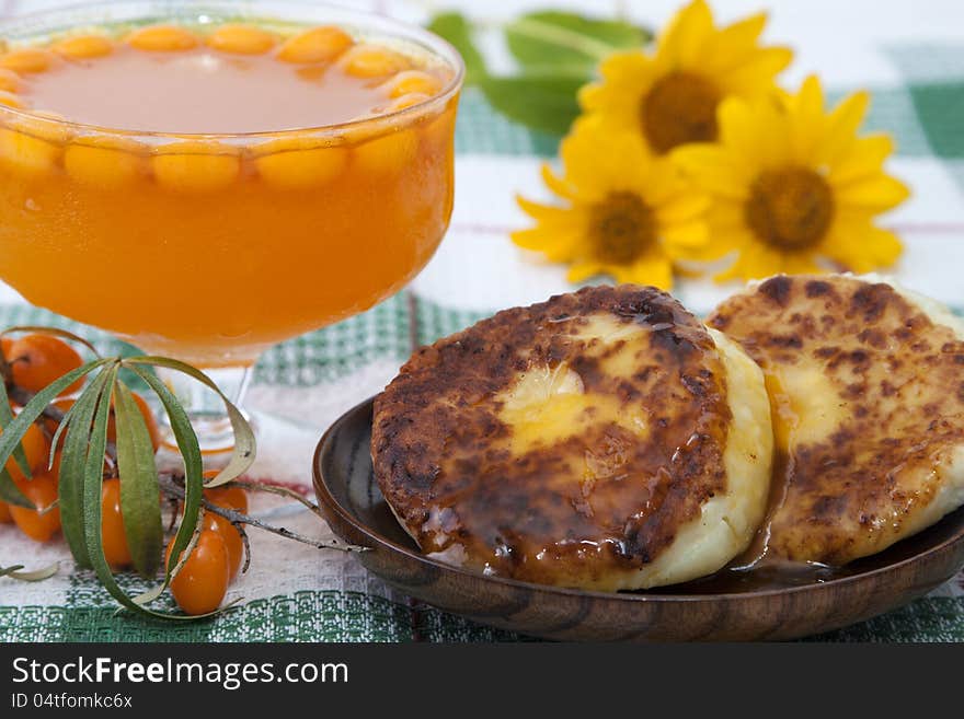 Jam from berries of sea buckthorn and cheese cakes . Jam from berries of sea buckthorn and cheese cakes .