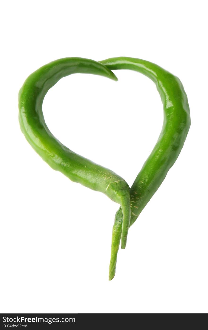 Two green peppers in a heart shape on a white