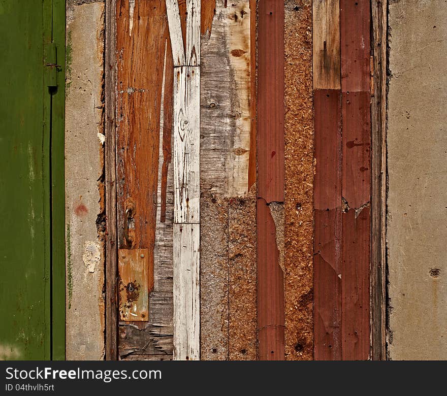 Aged damaged door made of various wooden materials