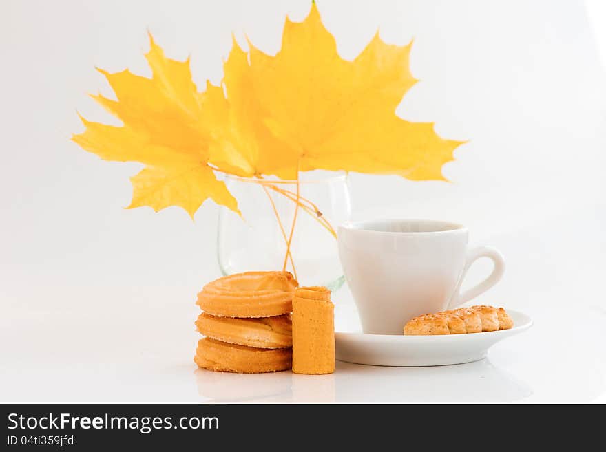 Coffee cup with cookies and yellow leaves