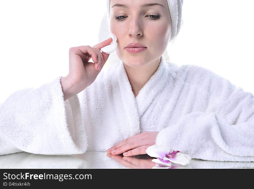 Beautiful woman in a white dressing gown cleaning your face. Beautiful woman in a white dressing gown cleaning your face