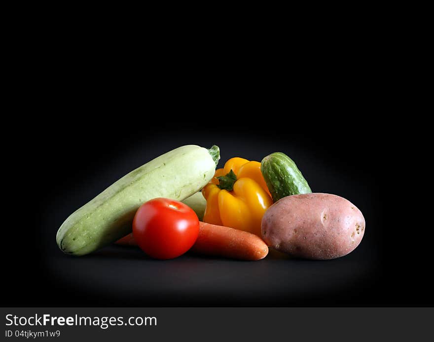 Heap of various raw vegetables on black background